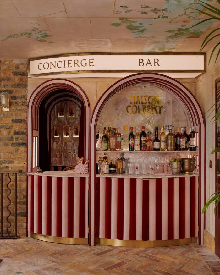 Concierge desk and bar designed by Buchanan Studio, with etched glass by Rupert Bevan and bespoke glasses by Laguna-B. The sculpture on the bar, Golden Balls, 2021, is by Charlotte Colbert. Ceiling mural by Ian Harper