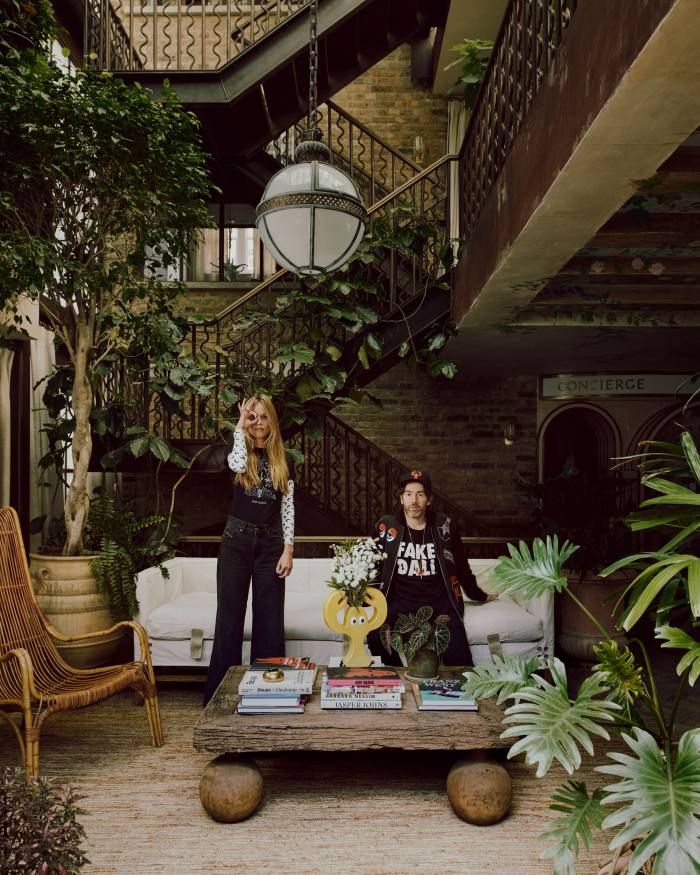 Philip and Charlotte Colbert in their “garden” living space, with a bespoke table by The French House, Howe sofa and a light fitting by Jamb. The lobster vase is by Philip Colbert