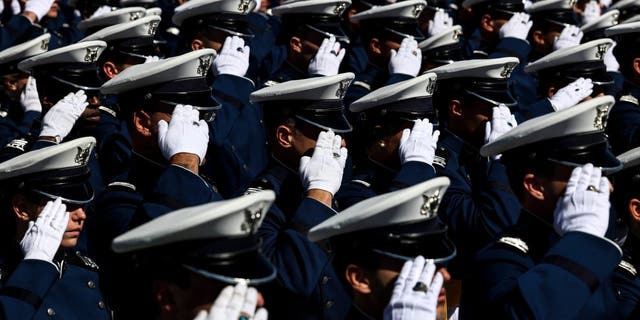 Air Force Academy cadets salute during the national anthem at Falcon Stadium for their graduation ceremony May 25, 2022, in Colorado Springs, Colo.