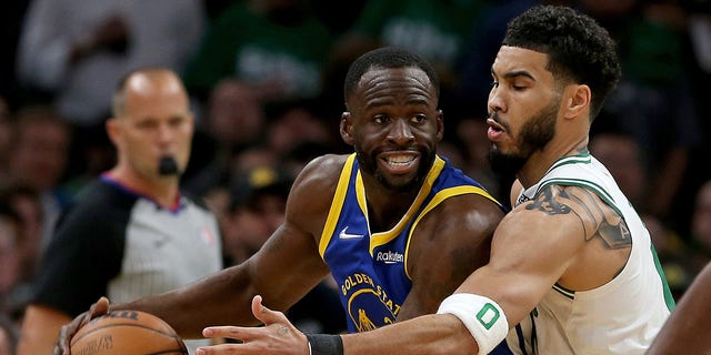Jayson Tatum of the Celtics guards Draymond Green of the Golden State Warriors during the NBA Finals on June 16, 2022, in Boston.