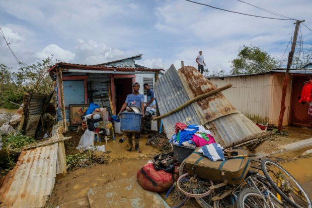 Neighbors work to recover their belongings that were saved from...