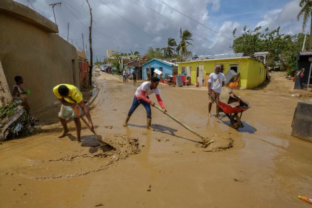 Locals clear mud brought by Hurricane Fiona in the Los...