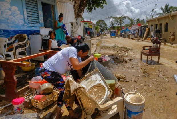 Residents work to recover belongings from flooding caused by Hurricane...