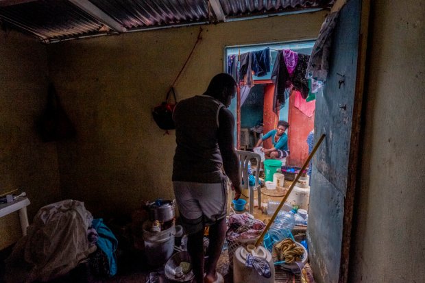 Neighbors work to recover their belongings from the flooding caused...