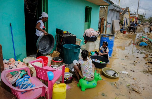 Neighbors work to recover their belongings from the flooding caused...