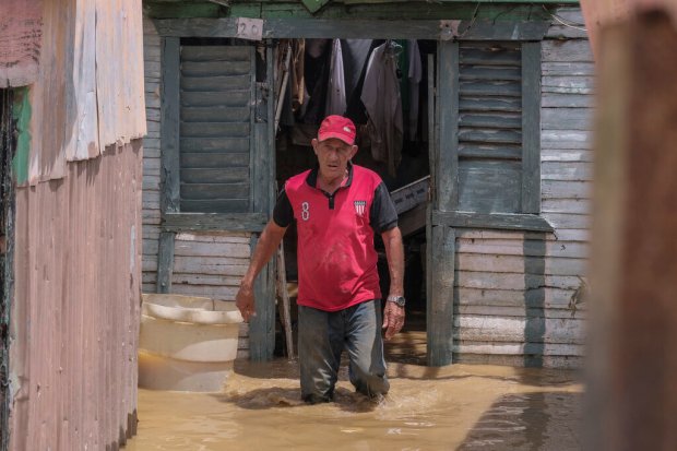 Nicasio Gil walks through the stagnant water left by the...