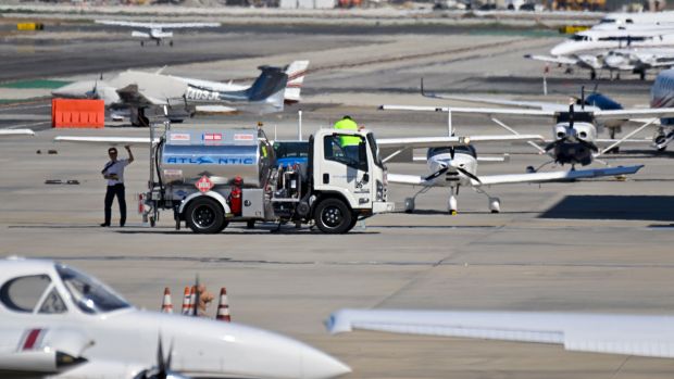 A worker fills a Cessna 172 with 100 low lead...