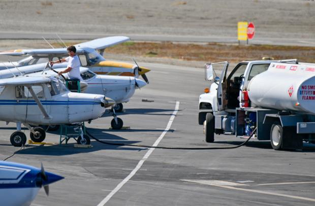 A worker fills a Cessna 172 with 100 low lead...